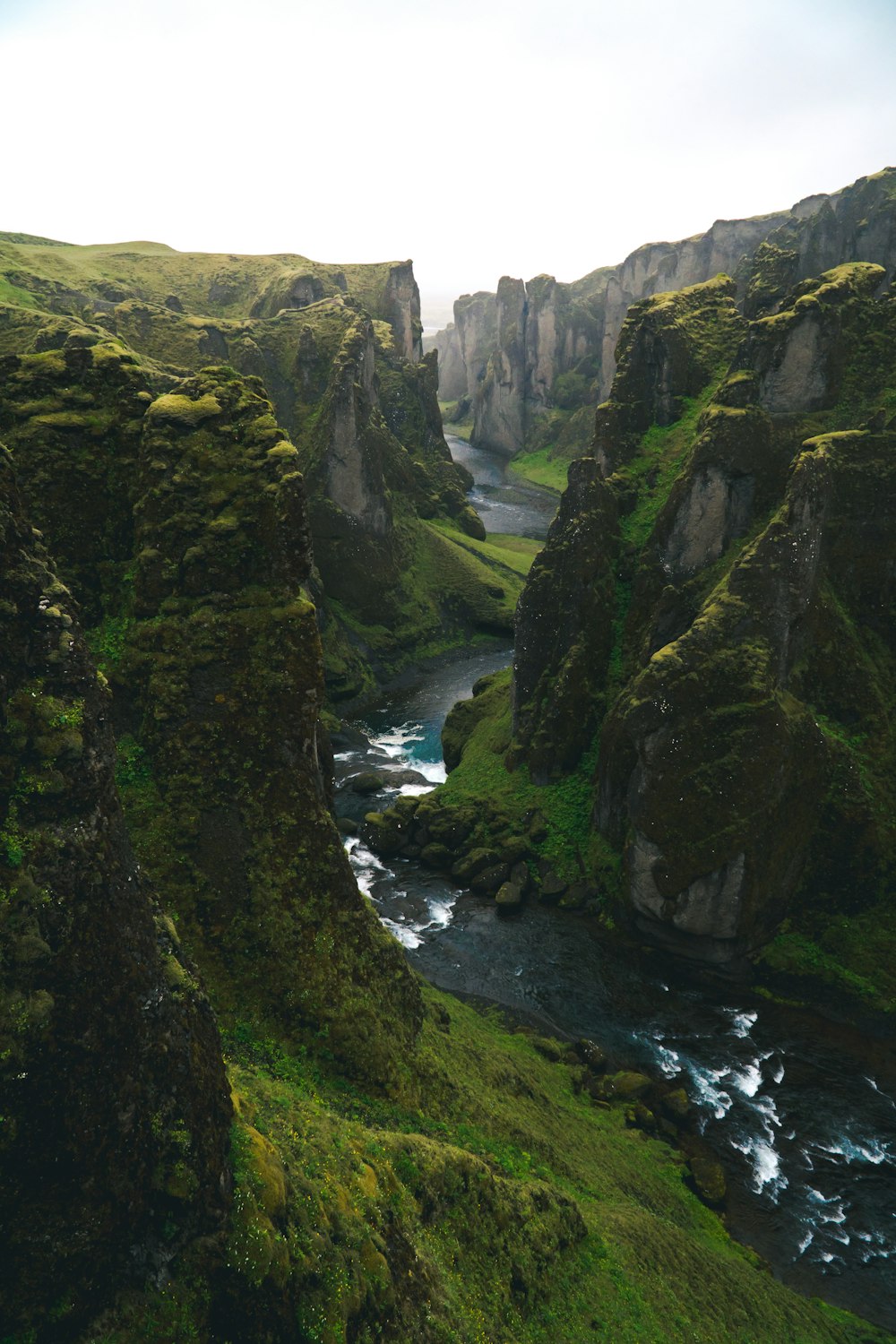 Photographie de vue aérienne d’un plan d’eau à travers les montagnes vertes