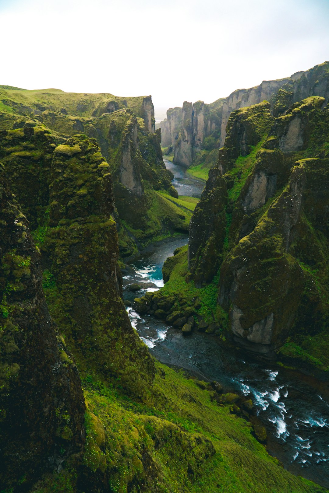 aerial view photography of body of water across green mountains