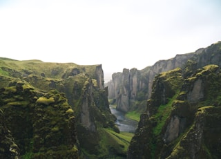 aerial view photography of body of water across green mountains