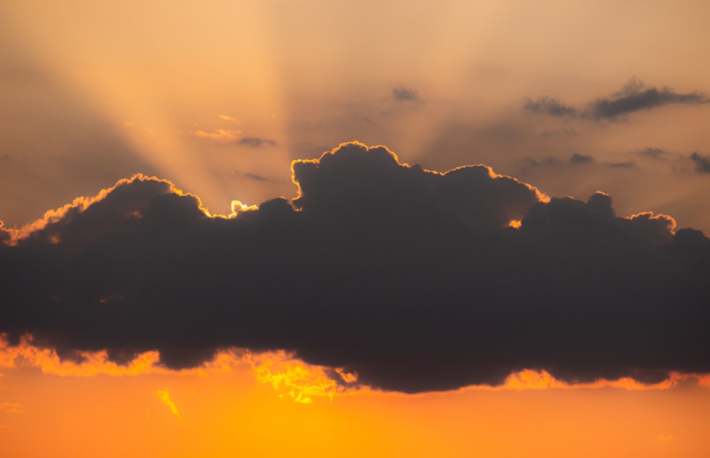 orangefarbener Himmel und dunkle Wolken bei Sonnenuntergang