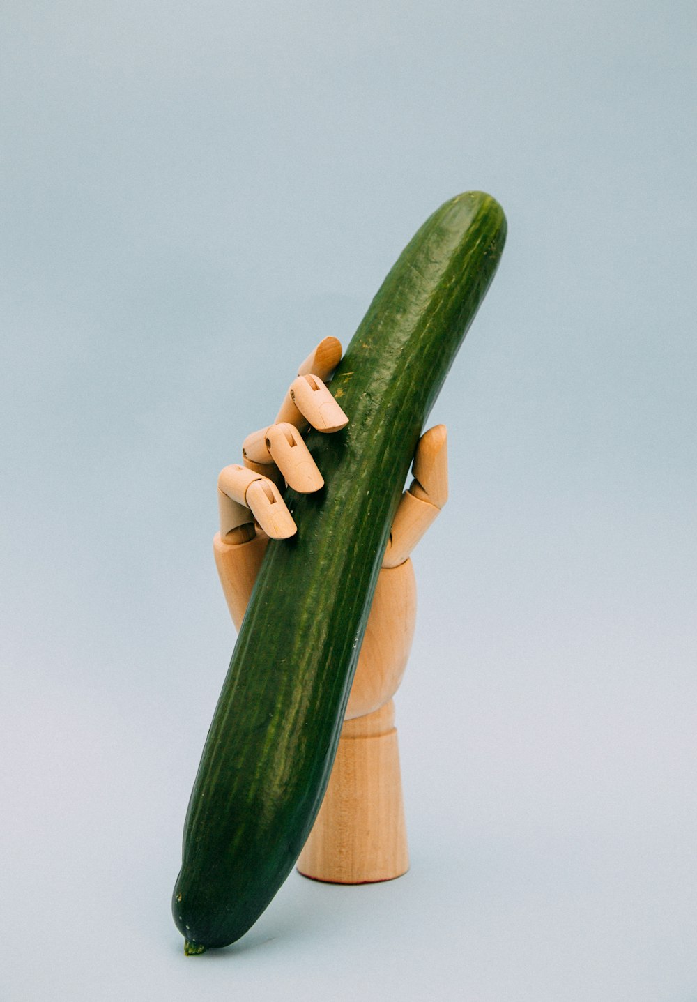 Persona que sostiene calabaza verde con estante de mano artificial