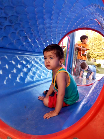 Children laughing and climbing through colorful tunnels in the indoor play center.