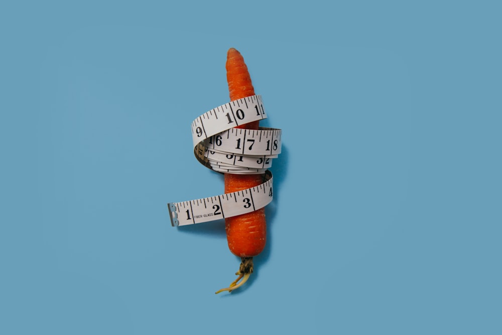 cinta métrica envuelta alrededor de la zanahoria