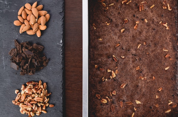 Almond, peanuts, and chocolate on gray surface