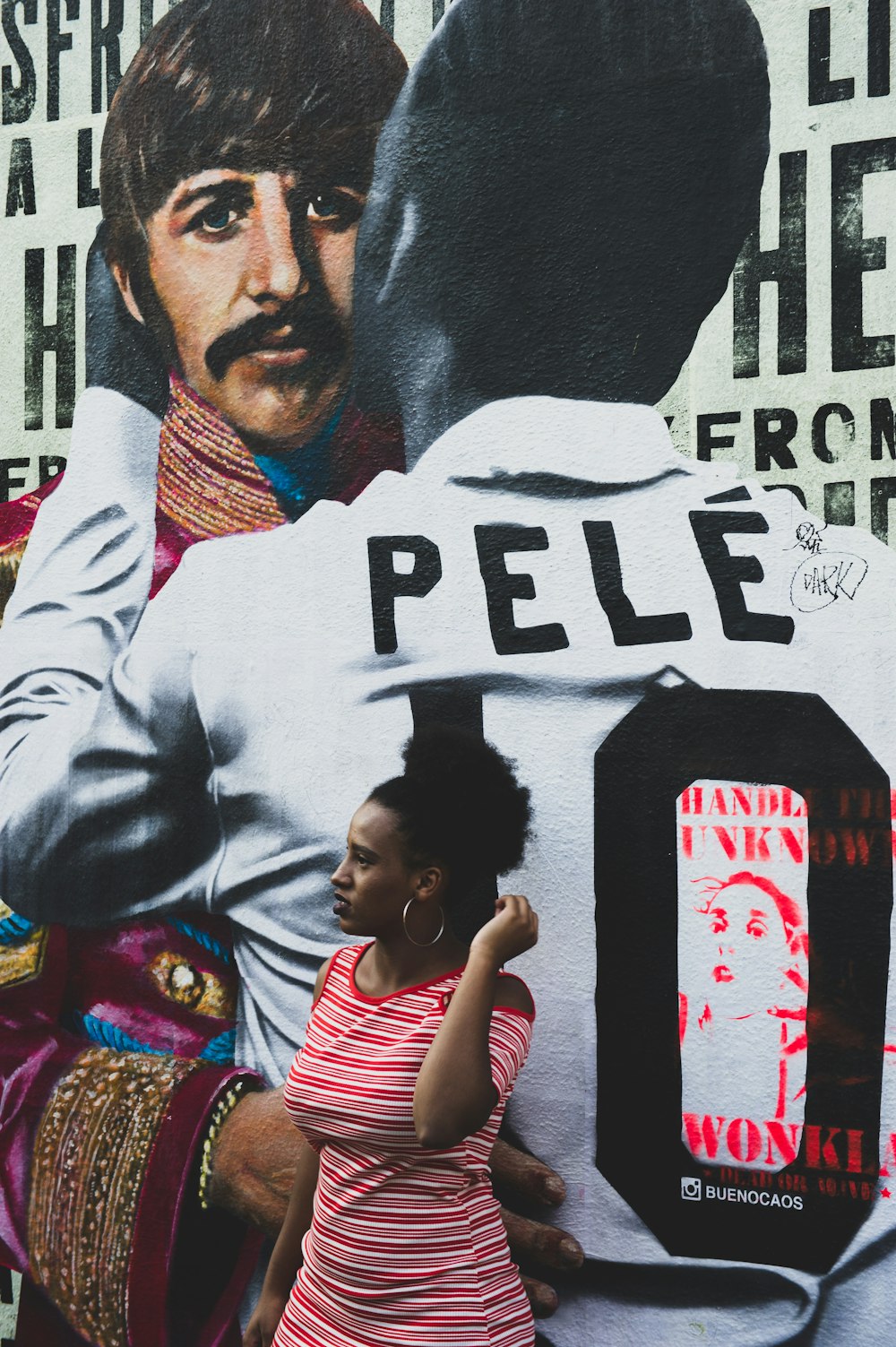 woman standing beside Pele wall