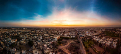 Aerial drone shot capturing a sprawling urban landscape at sunset with warm tones.