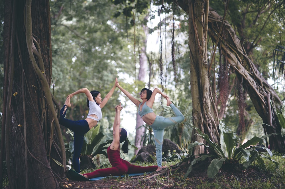 Três mulheres fazendo yoga na floresta