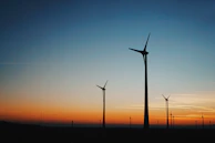 Sunset silhouette of wind turbines standing tall, symbolizing sustainable progress.