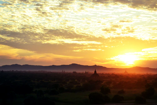 A vibrant aerial shot of the iconic Prambanan temple at sunset, captured by a drone.