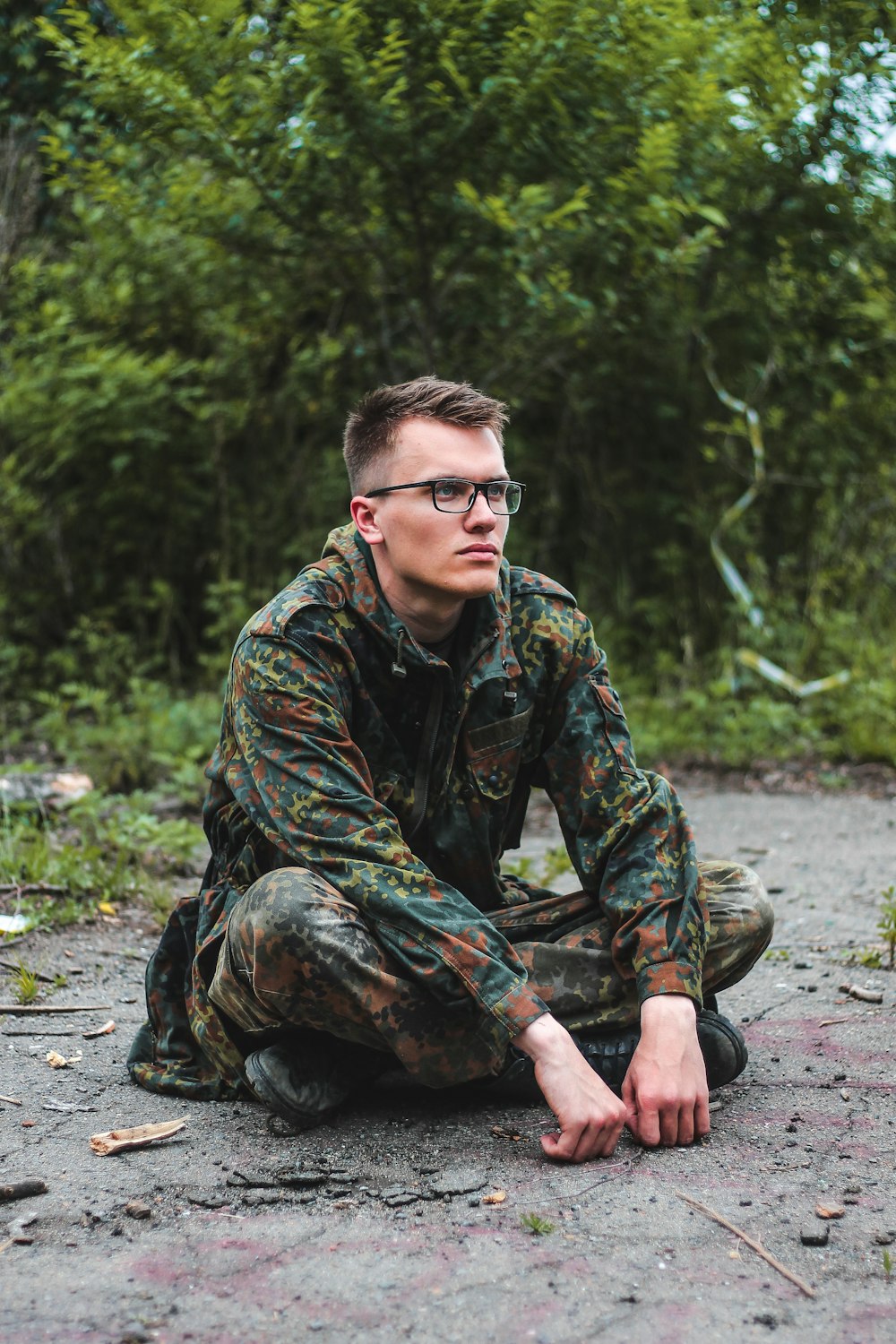 man in multicolored coat sitting on ground