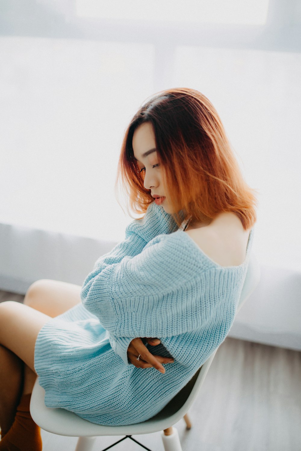 woman in teal knitted dress sitting on chair