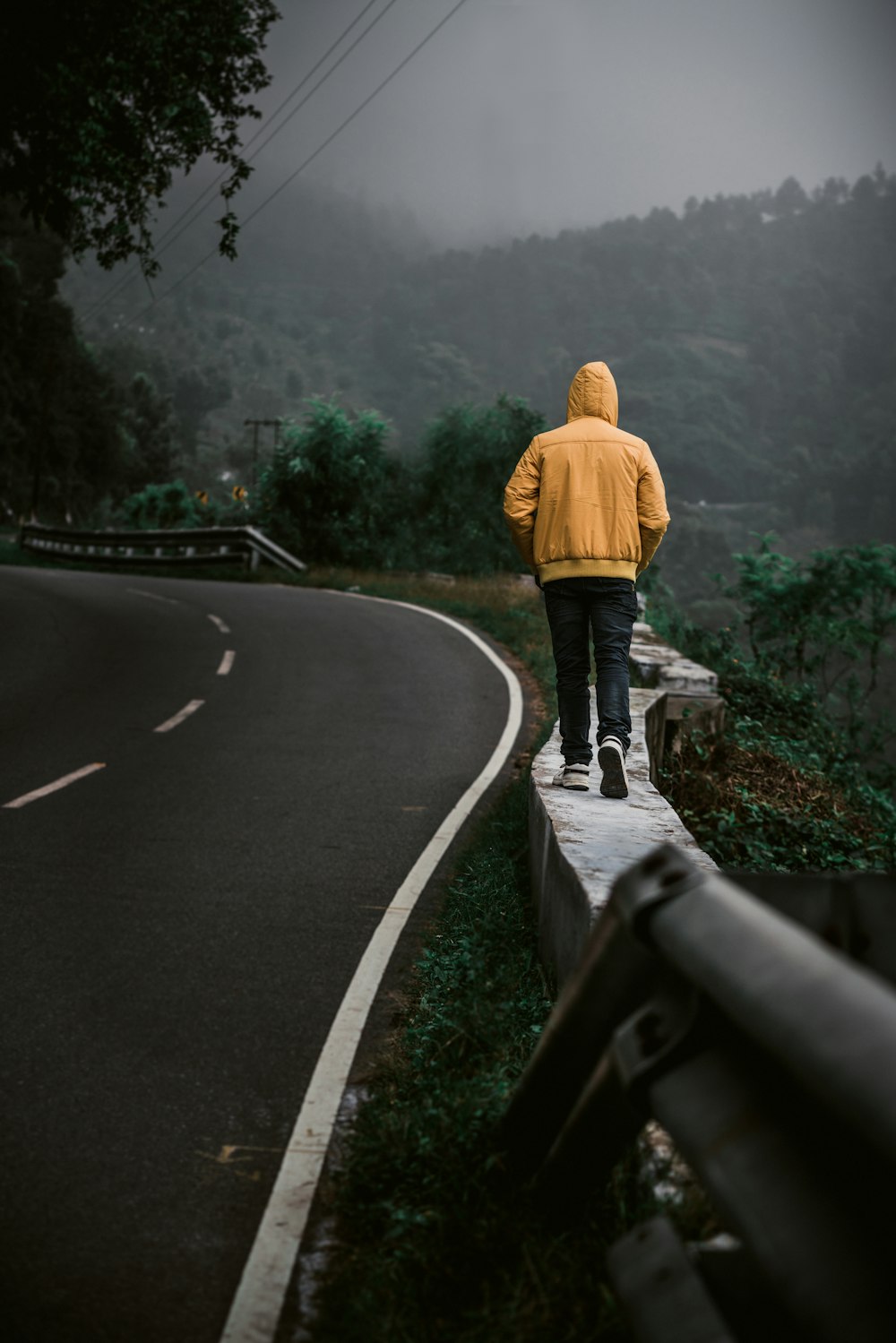 道路脇のプラットホームを歩く男