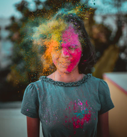 A vibrant splash of pink and orange powders thrown in the air during Holi celebration.