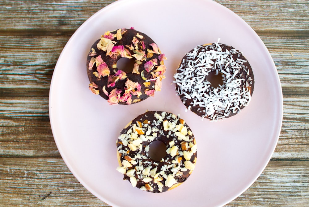 three doughnuts on white ceramic plate