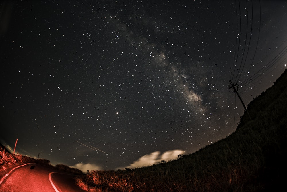 red lighted road under starry sky