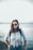 woman in blue crop-top standing beside body of water