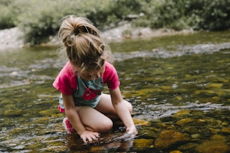 girl playing on body of water