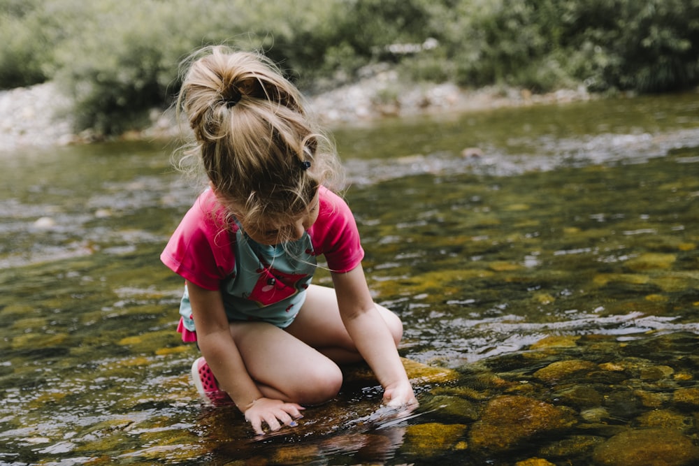 girl playing on body of water