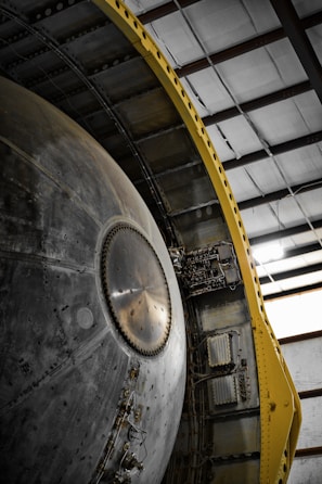 Close-up of a red and black heavy metal structure with precise welds in an industrial setting