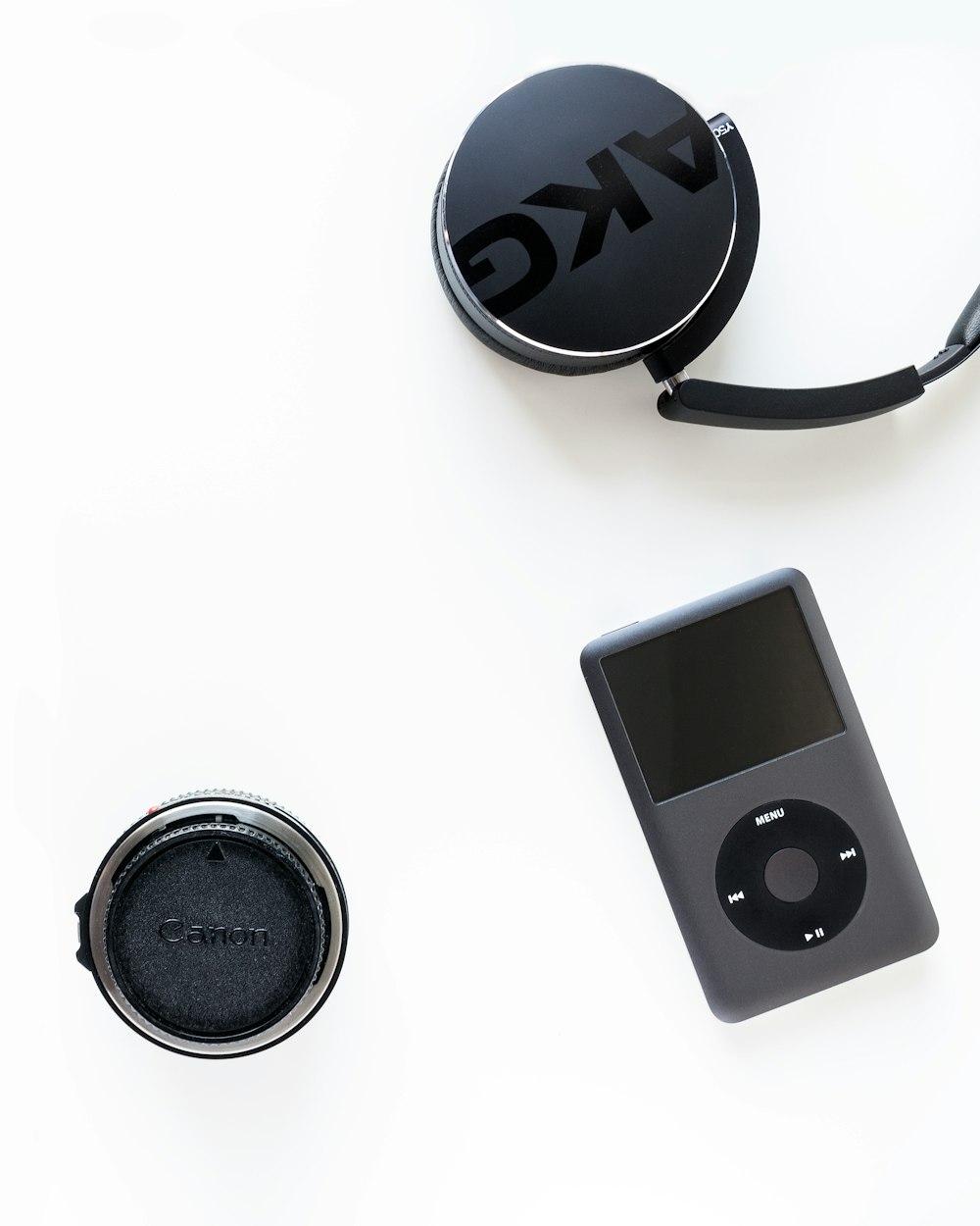iPod clásico negro junto a la lente de la cámara Canon negra