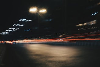 Blurred lights of passing cars on Queen Street West casting streaks of color.