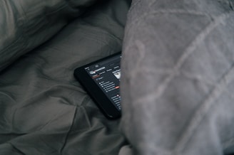 black Android smartphone on gray sheet