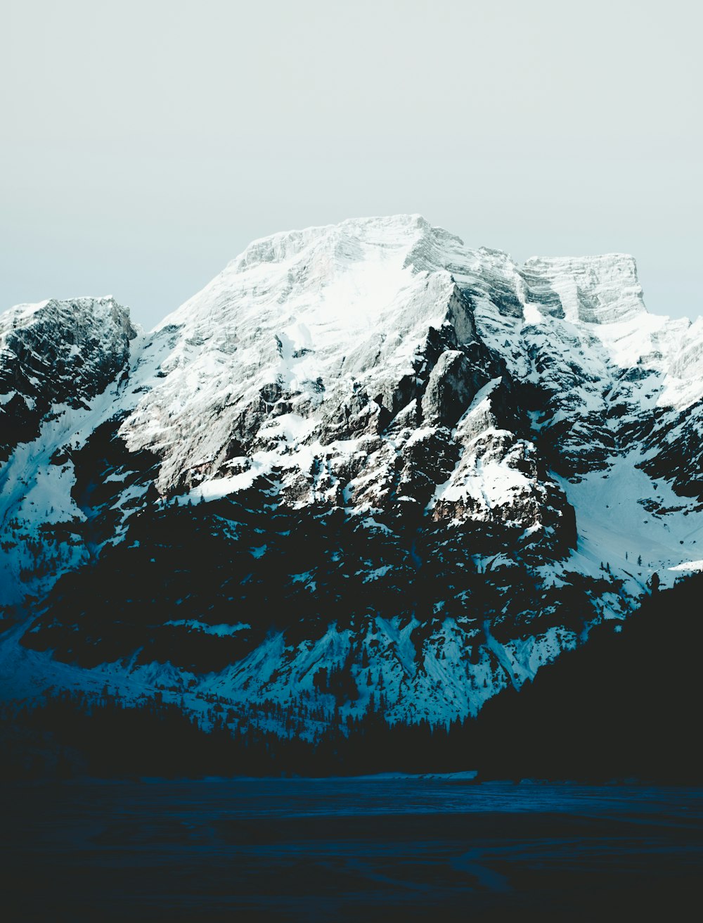 snow-capped mountain under gray sky