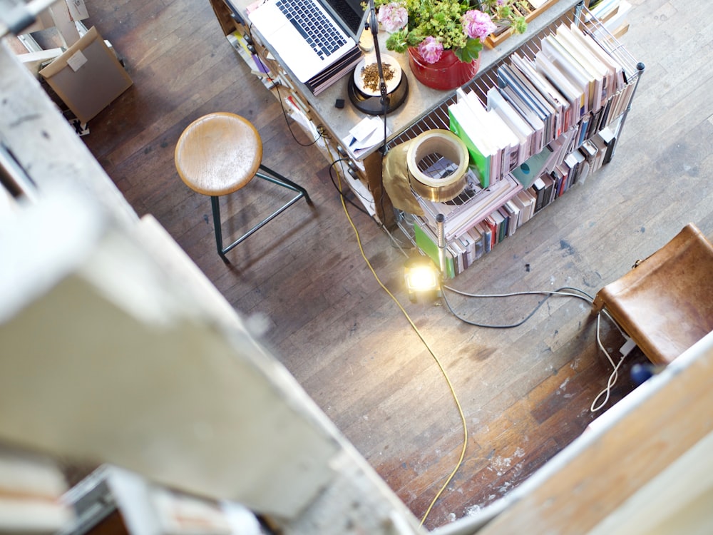 chaise à côté d’un bureau avec ordinateur portable et collection de livres