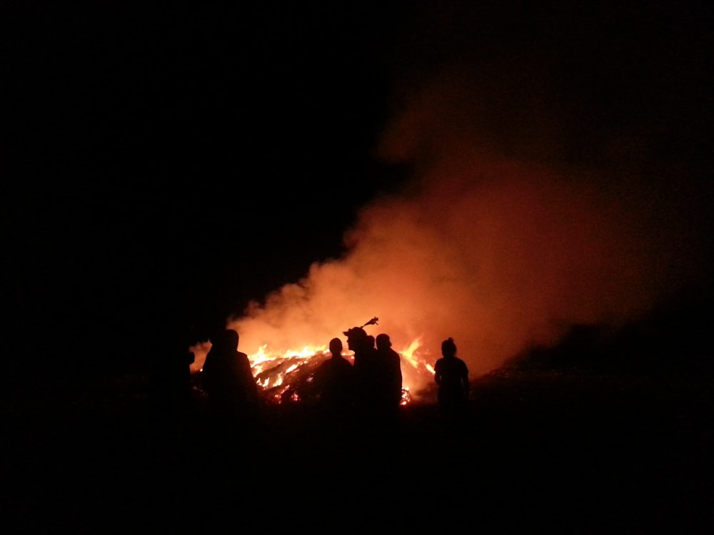 silhouette of people facing fire