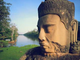 A serene riverside scene with an ancient book of Shrimad Bhagwat Geeta resting on a stone.