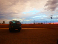 A mobile repair van parked by a roadside assisting a driver in need under clear blue skies.