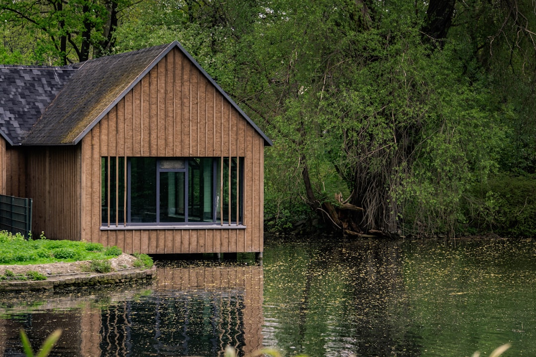 brown wooden cabin near river at daytime