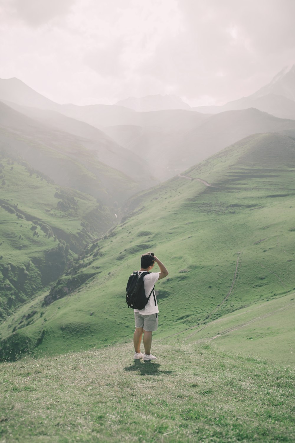 man standing on green mountain