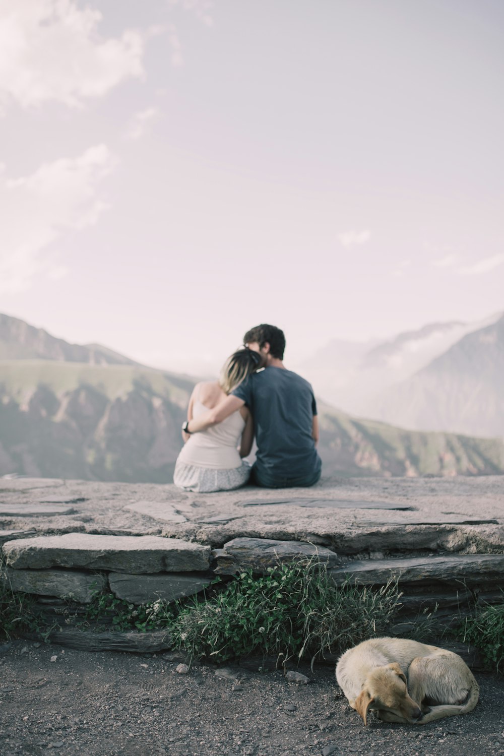 hombre y mujer mirando hacia atrás mientras que la cabeza de la mujer en el hombro del hombre en la punta de la colina