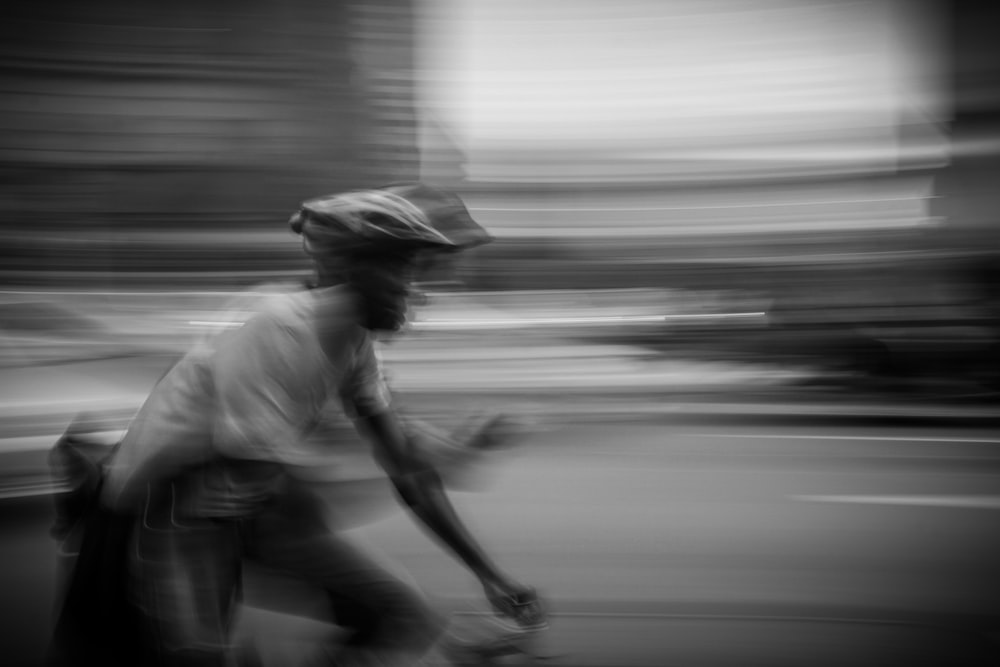 panning photography of man riding bike