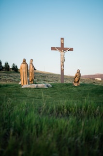 Crucifix statue on green grass