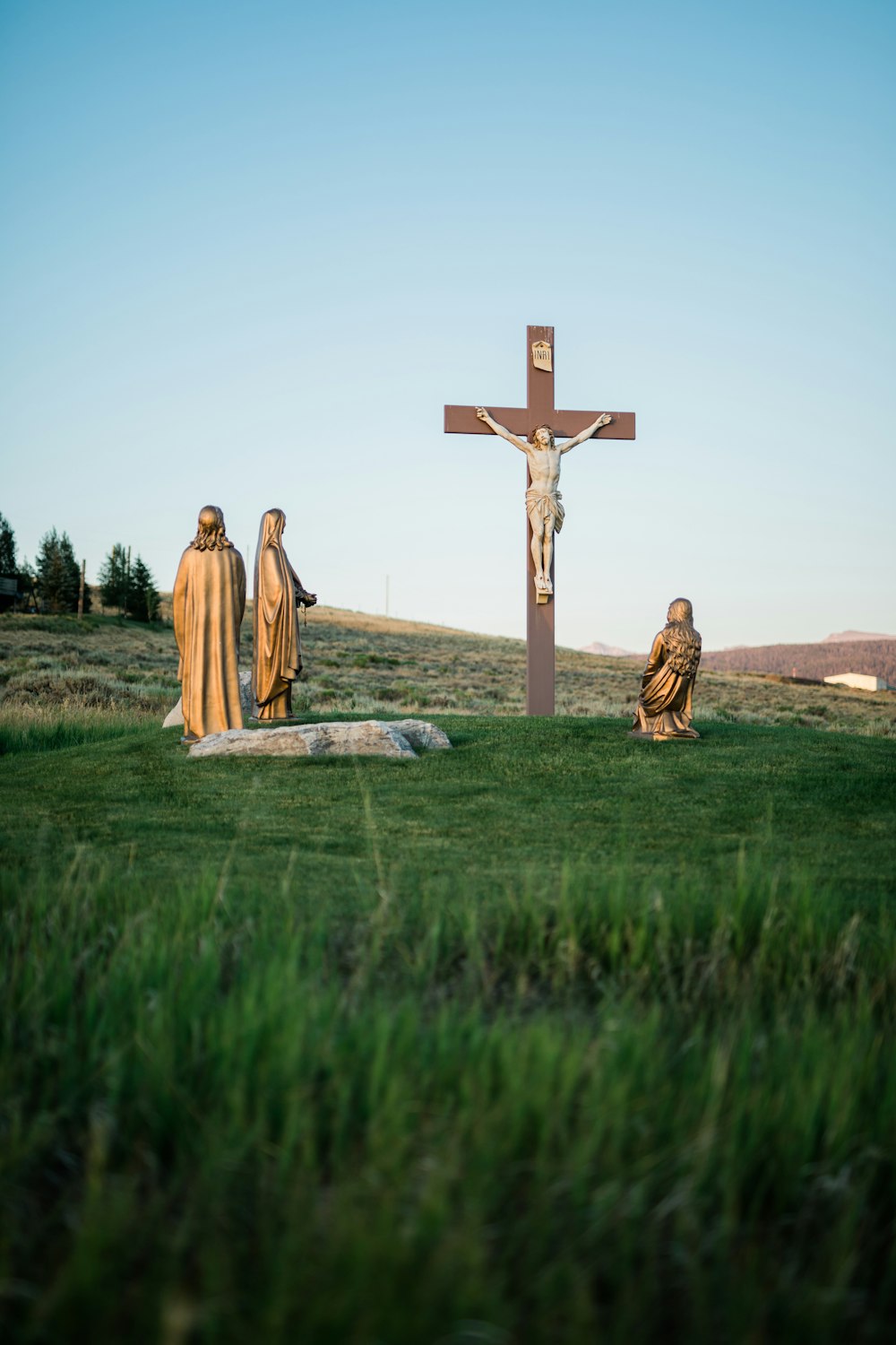 Crucifix statue on green grass