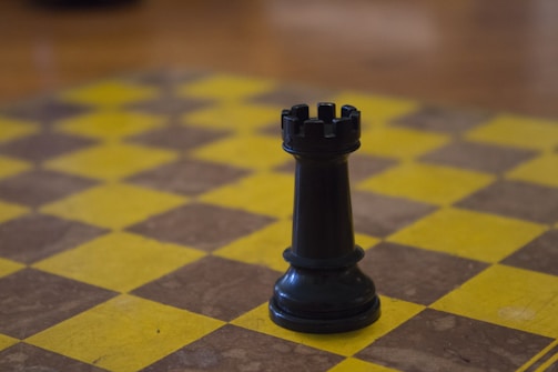 Close-up of a chessboard with a focus on the rook piece.
