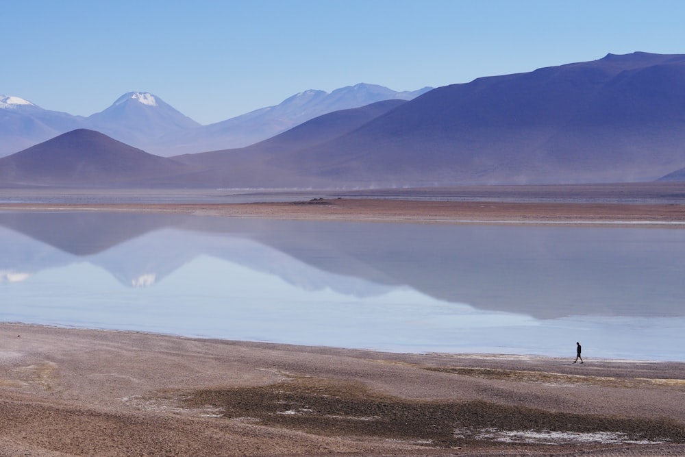 homem caminhando ao lado do lago