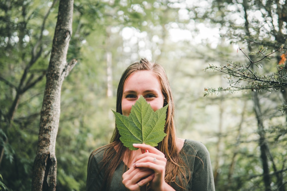 woman covering her face with leaf