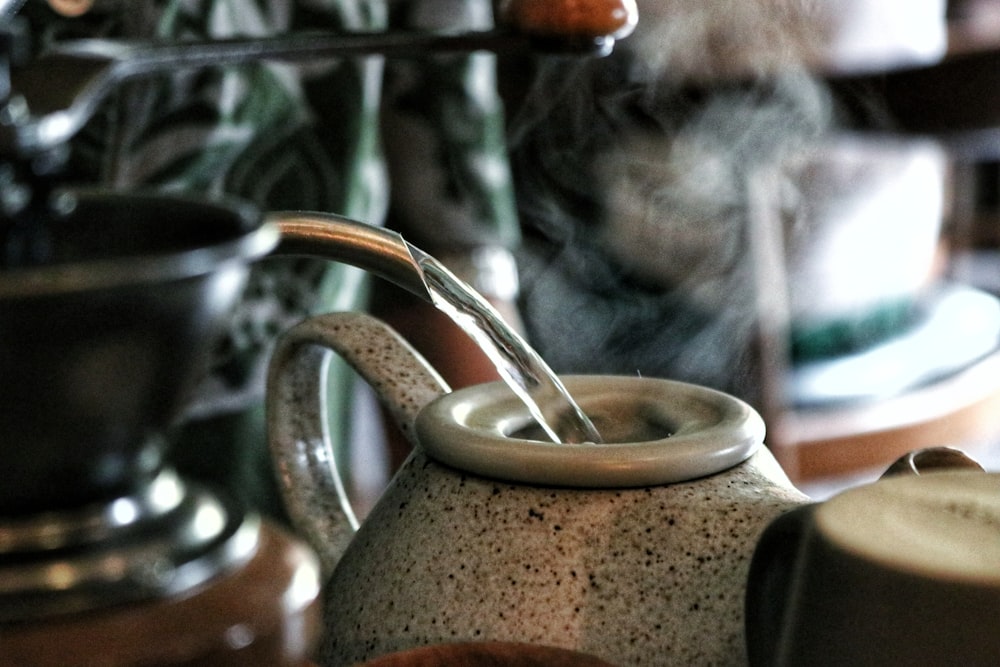 selective focus photograph of water pouring on gray pto