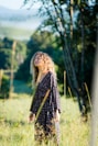 woman in black long-sleeved dress standing on grass field