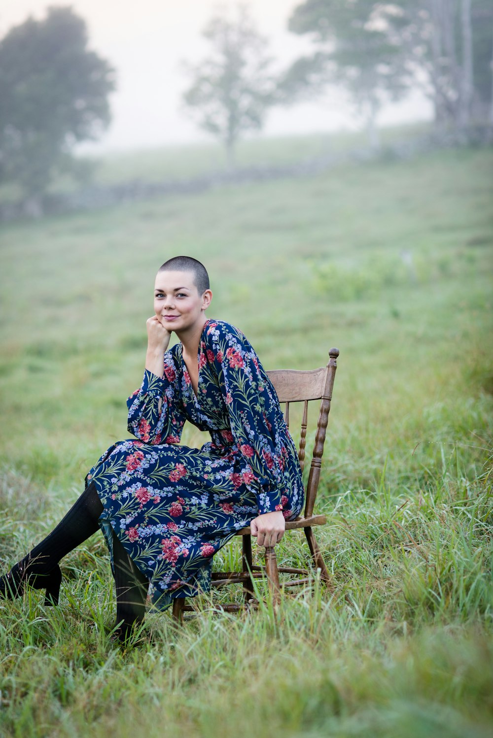 woman sitting on chair surrounded by grass field