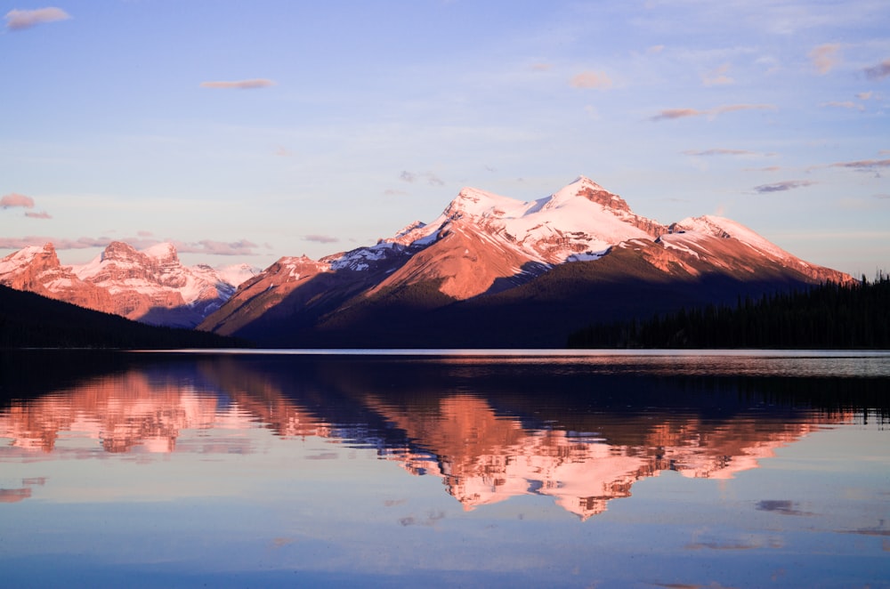 body of water within mountain range during daytime