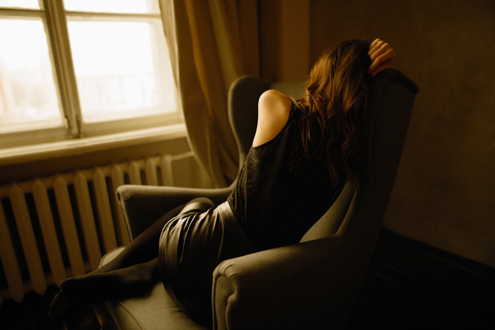 woman sitting on wing chair