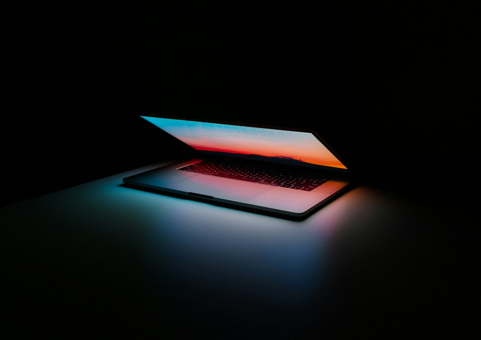 Laptop half opened in a dark room