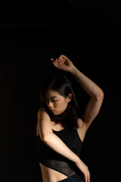 A graceful contemporary dancer stretching elegantly against a soft, glowing backdrop.