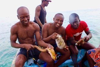 A group of happy anglers holding their catch during a salary fishing trip near the coral reefs.