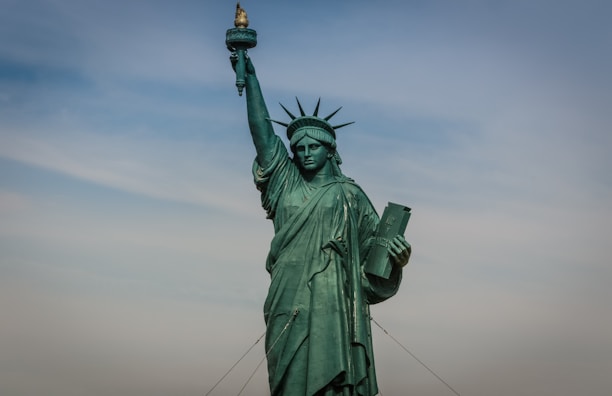 A close-up of the Statue of Liberty taken from a sightseeing boat on a sunny day.