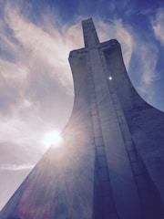 A towering architectural structure framed against soft natural light, highlighting scale.
